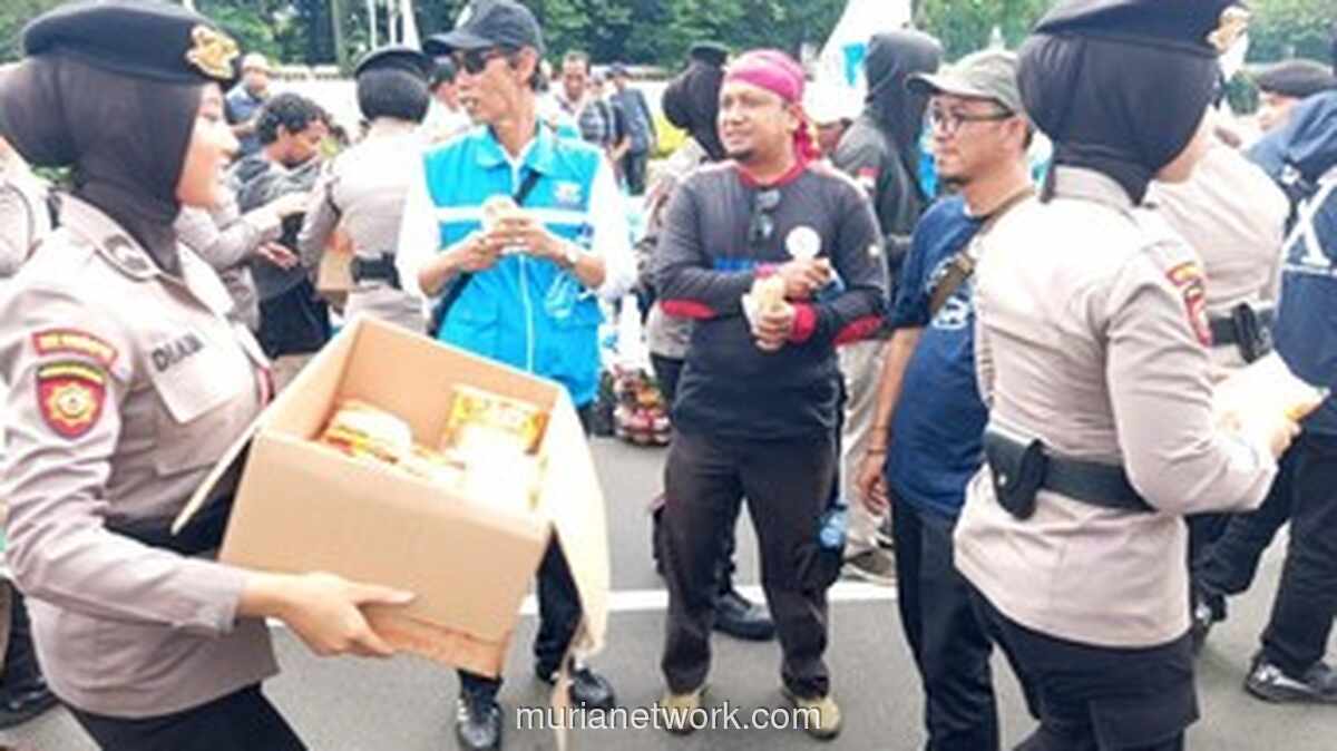 Polisi Wanita Bagi-bagi Roti di Tengah Unjuk Rasa Buruh