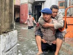 Brimob Gendong Warga Sakit di Tengah Genangan Kedaung Kali Angke