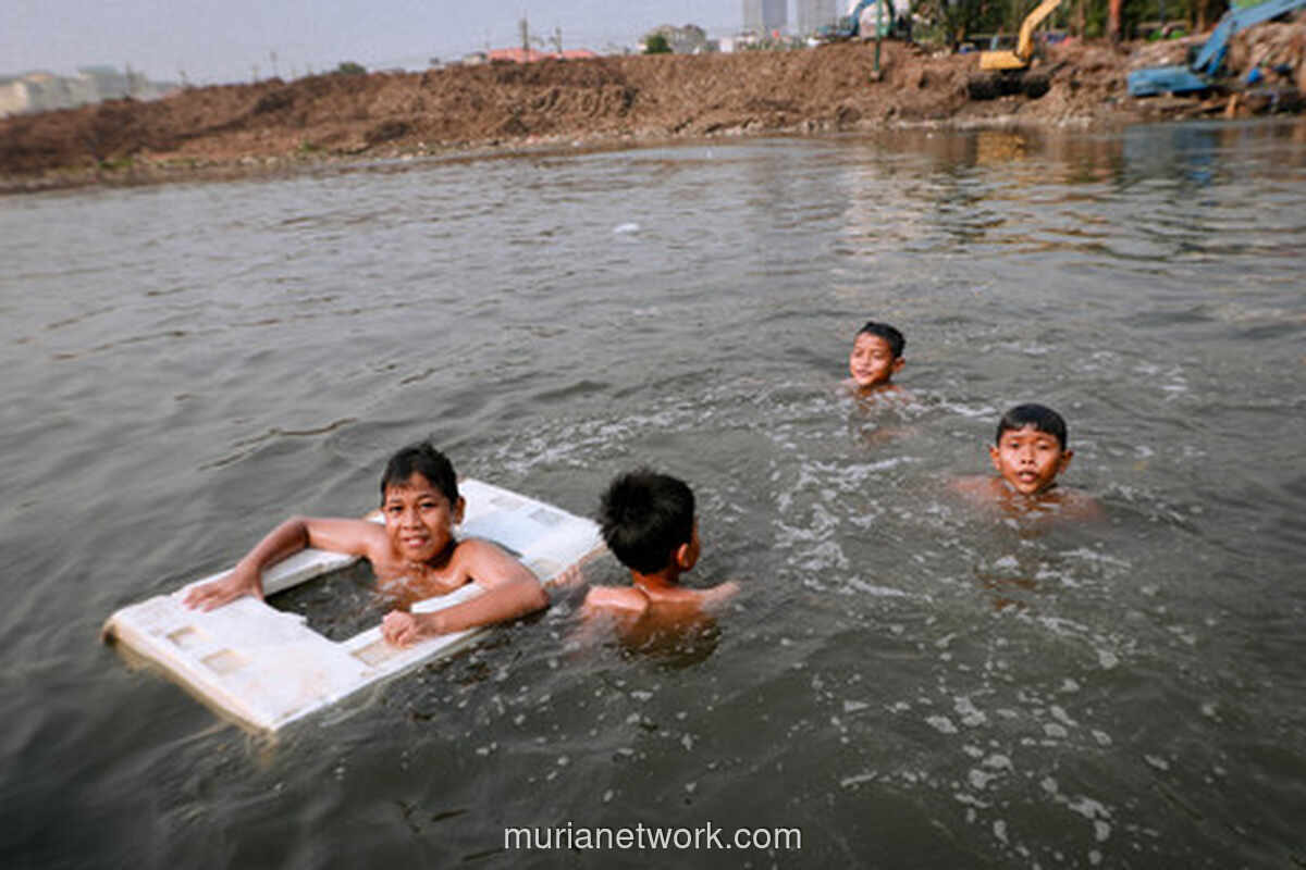Anak-Anak Manfaatkan Kemarau untuk Berenang di Kali Ciliwung